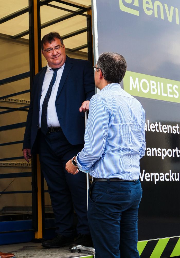 Nils Brusius (Geschäftsleitung Enviro Group) und Marc Weinmeister (Staatssekretär Hessen) bei der Begutachtung des mobilen Test-Centers in Haiger